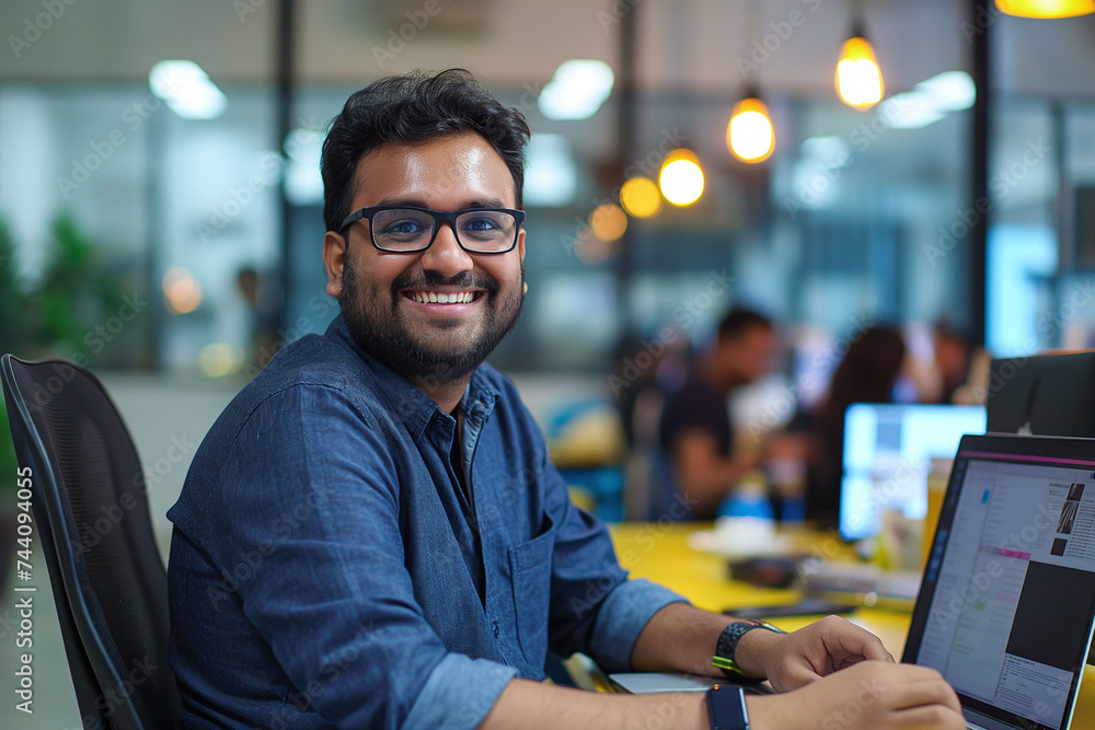 Portrait of a indian tech employee working on laptop at office