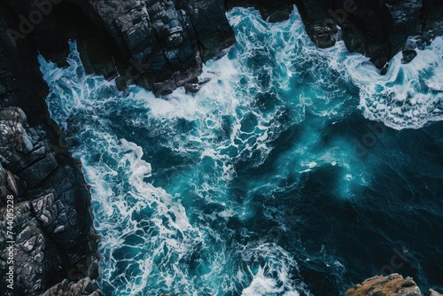 This aerial photograph captures the vast expanse of the ocean meeting the rugged rocks along the coastline, Panoramic aerial view of the roaring sea making waves with rocky shores, AI Generated