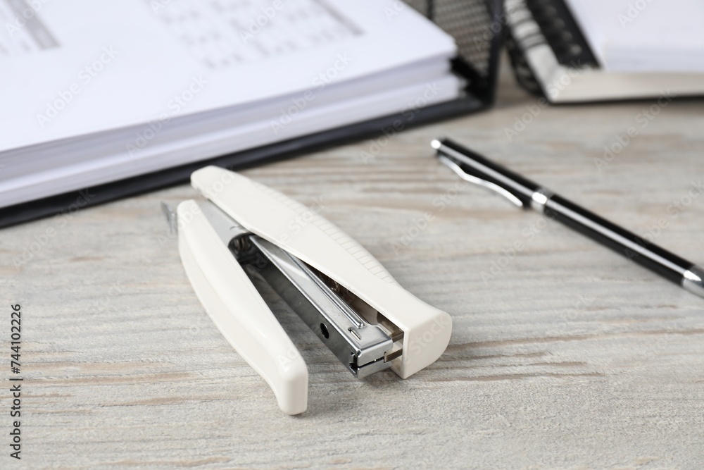 Stapler on wooden table, closeup. Office stationery Stapler on wooden table, closeup. Office stationery