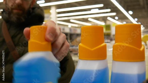 Close-up of detegent or solvent bottles in a hardware store and a buyer chooses one