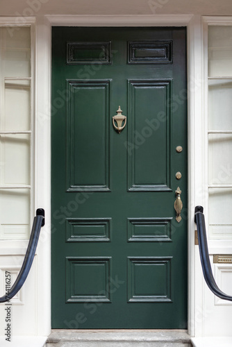 The green front door radiates timeless elegance and invites with a touch of vibrancy in New England.