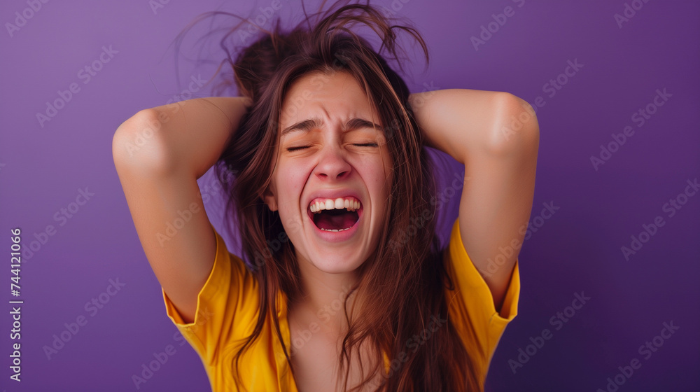 Stressed young woman screaming with hands in hair against purple background