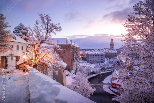 Winter view of Cesky Krumlov, picturesque houses under the castle with snow-covered roofs. Narrow streets and the Vltava river. Travel and Holiday. Christmas time. UNESCO World Heritage. Czechia