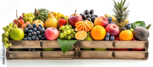 A wooden crate filled with a variety of fresh exotic fruits, neatly arranged on a white background.