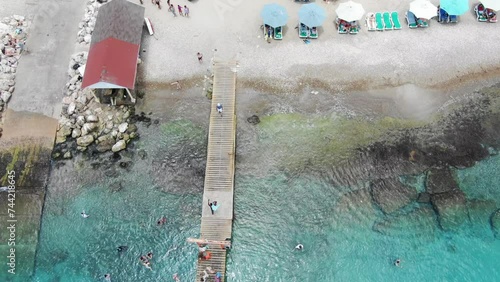 Playa piskado in curacao with colorful beach umbrellas and boats, aerial view photo