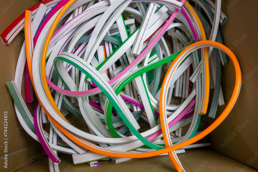 Flexible neon LED strips in a box at the factory.Remnants of lighting strips for outdoor advertising.