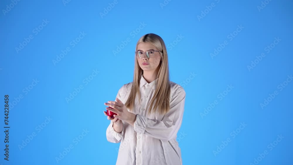 Caucasian young lady plays with an apple in smart glasses teacher look biting the fruit Caucasian young lady plays with an apple in smart glasses teacher look biting the fruit