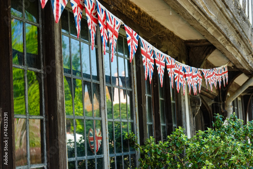 CLOSE UP: String of Union Jack flags strewn under wooden beams of an old house photo