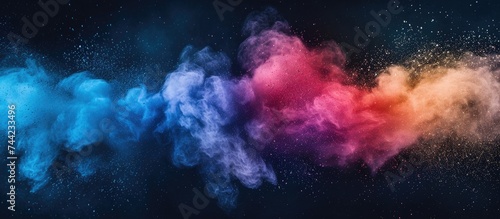 A group of multicolored smokes explode in an energetic burst against a black backdrop.