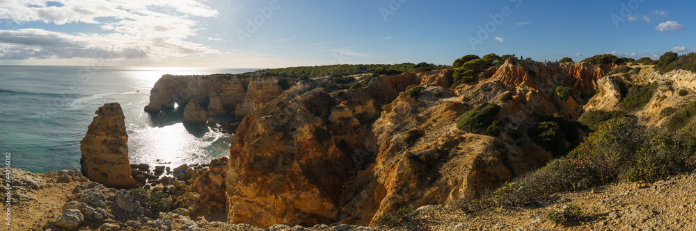 Panorama of golden rock cliffs at the coastline of the Atlantic Ocean with near the Cave of Benagil, Algarve, Portugal