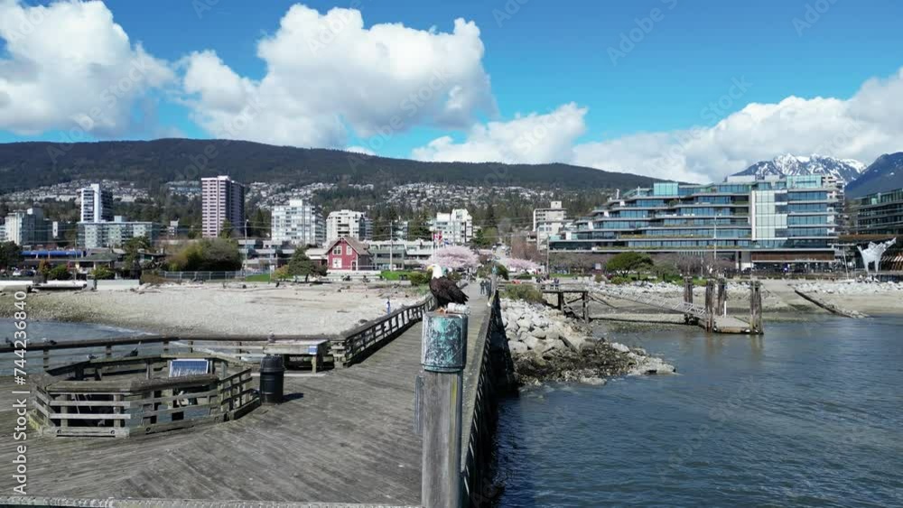Close-up view of a pier on a coast with a background of modern buildings Close-up view of a pier on a coast with a background of modern buildings