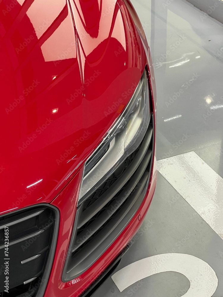 Vertical shot of details on a red glossy luxurious car surface