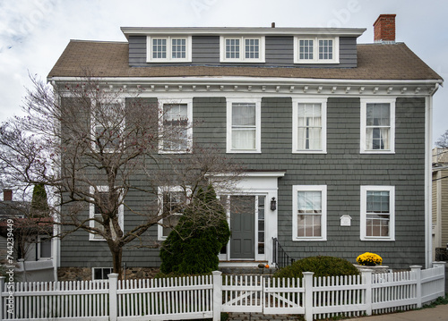 Spacious gray house behind white picket fence