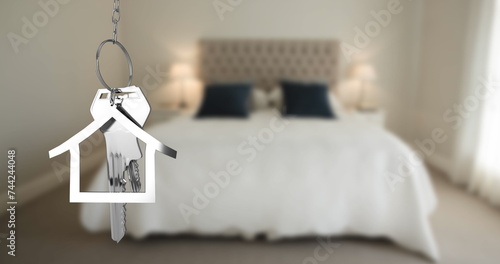 Image of silver house keys and house shaped key fob hanging over an out of focus bedroom 4k