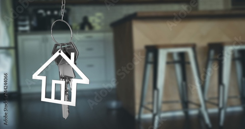 Image of silver house keys and house shaped key fob hanging over an out of focus open plan kitchen 4