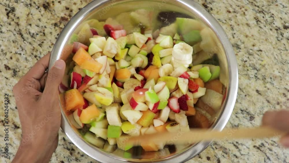 Mixing healthy fruit salad rich with vitamins and nutrition Mixing healthy fruit salad rich with vitamins and nutrition