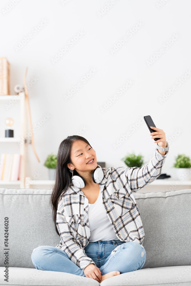 Vertical photo of a chinese woman relaxed at home taking a selfie Vertical photo of a chinese woman relaxed at home taking a selfie