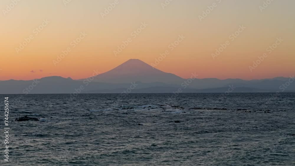 Stunning sunset view of Mt. Fuji silhouette with ocean Stunning sunset view of Mt. Fuji silhouette with ocean