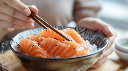 Close-up hand holding chopsticks to hold salmon sashimi. japanese food. generative AI image photo
