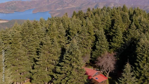 Red timber cabin in middle of deep Mediteerraen Lake Kirkinis in summer photo