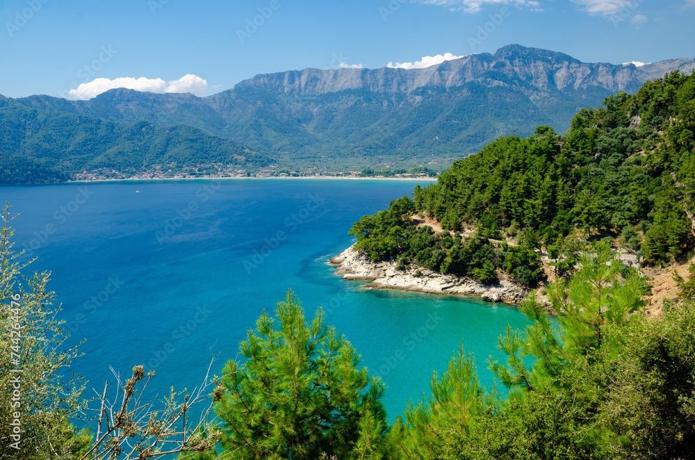 Scenic view of vibrant blue waters with distant mountains in Thassos, Greece