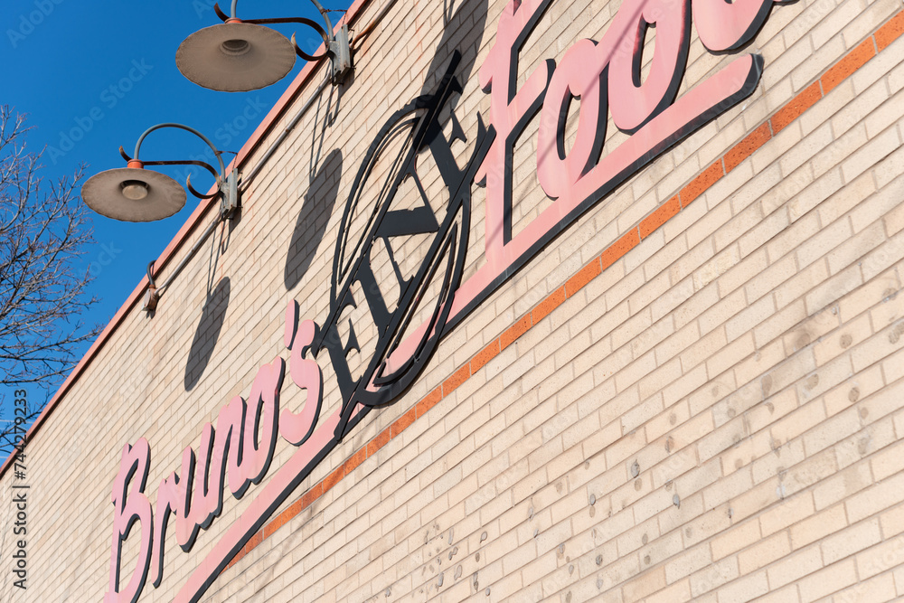 exterior brick wall and lamps over an outdoor sign for Bruno's Fine