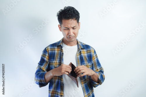 Adult Asian man looking camera with sad expression while open his wallet photo