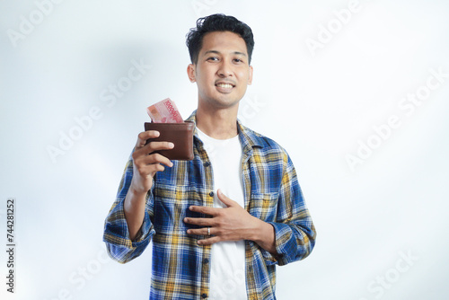 Adult Asian man smiling happy while showing his wallet full of paper money photo
