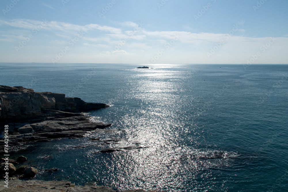 Seascape with rocks and horizon on a sunny day