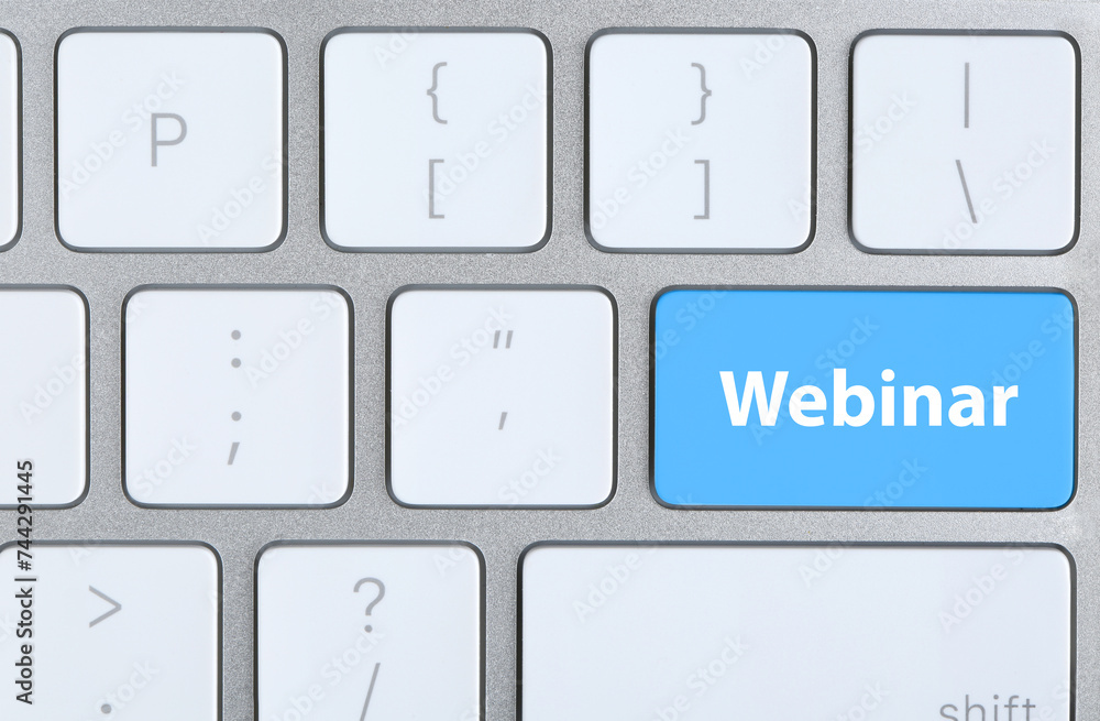 Light blue button with word Webinar on computer keyboard, top view