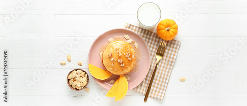 Composition with tasty pumpkin pancakes on white wooden background, top view photo