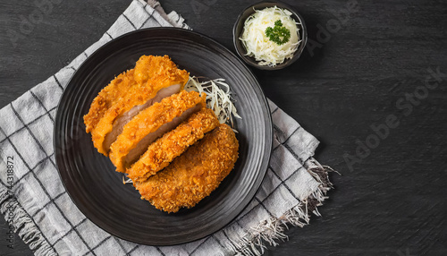 Tonkatsu sliced. top view of breaded deep fried pork cutlet on black plate, japanese food, copy space