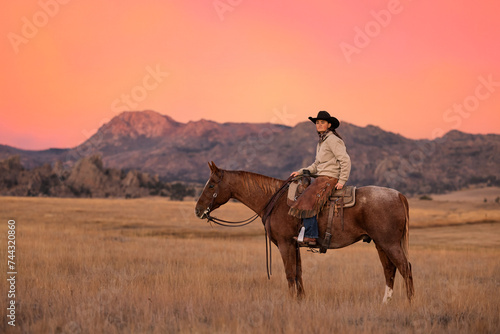 Wyoming Cowgirl portrait on horse with colorful sky