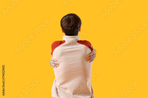 Young man hugging himself o...