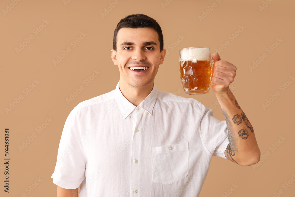 Handsome young happy man with mug of beer on brown background Handsome young happy man with mug of beer on brown background