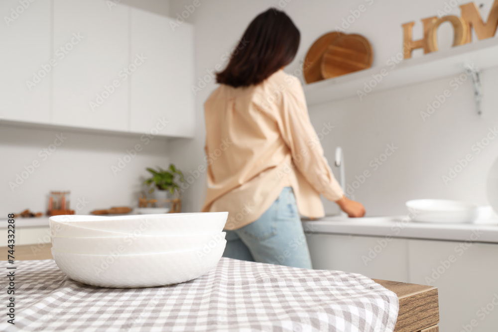 Beautiful young woman with clean dishes in kitchen Beautiful young woman with clean dishes in kitchen