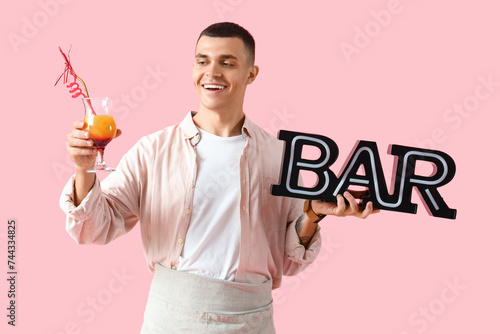 Young male bartender with g...