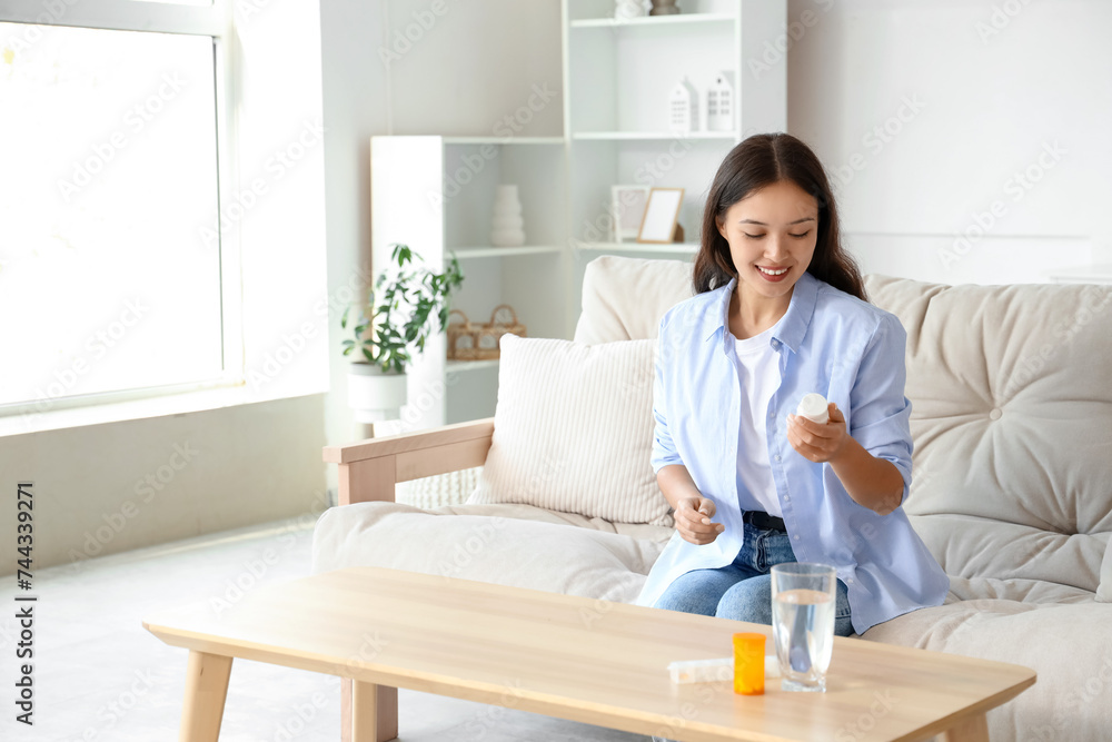 Young Asian woman reading pills description at home Young Asian woman reading pills description at home