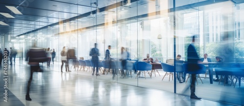  Bright business workplace with people in walking in blurred motion