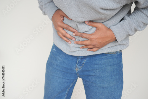 young man suffering stomach pain close up.