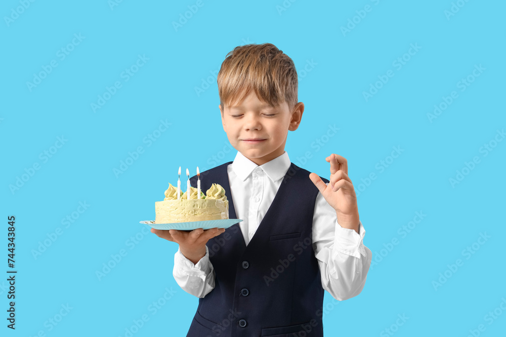 Cute little boy with Birthday cake making wish on blue background Cute little boy with Birthday cake making wish on blue background