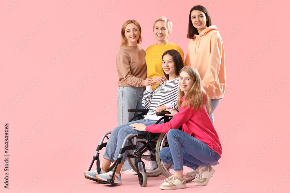 Group of people with young woman in wheelchair on pink background