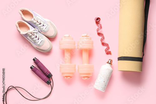 Composition with sports equipment and shoes on pink background