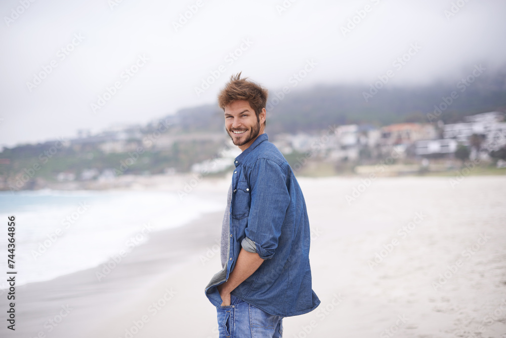 Portrait, beach and man with a smile, vacation and summer holiday with weekend break and water. Waves, face and person with happiness and guy with seaside and travel with peace and wind with nature Portrait, beach and man with a smile, vacation and summer holiday with weekend break and water. Waves, face and person with happiness and guy with seaside and travel with peace and wind with nature