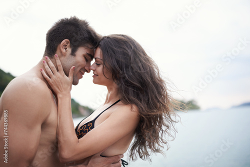 Couple, touch and travel to ocean on vacation, love and relax by water on summer holiday. People, swimwear and bonding for relationship in outdoors, support and hug on weekend trip to sea or nature
