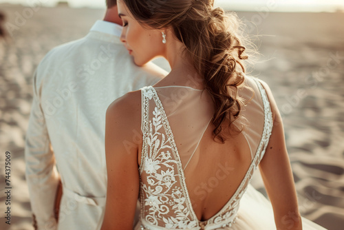 close up of bride and groom wearing suit and wedding dress at the sea on the beach