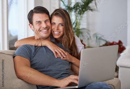 Portrait, smile and couple with laptop on sofa networking on social media, website or internet. Happy, love and female person embracing husband read online blog with computer in living room at home.