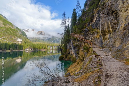 beautiful landscape of mountain lake Braies in the Dolomites, Italy. Hiking trail along the lake and low clouds over the mountain