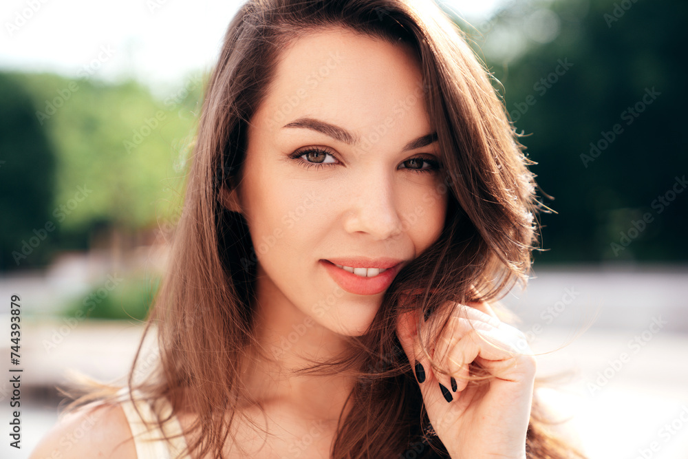 Portrait of young beautiful smiling woman in trendy summer clothes. Sexy carefree woman posing in the street at sunset. Positive model outdoors at sunny day. Cheerful and happy. Closeup Portrait of young beautiful smiling woman in trendy summer clothes. Sexy carefree woman posing in the street at sunset. Positive model outdoors at sunny day. Cheerful and happy. Closeup