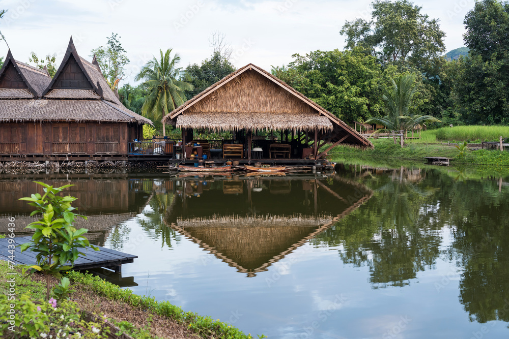 Traditional wooden thai house by canal with wood boat